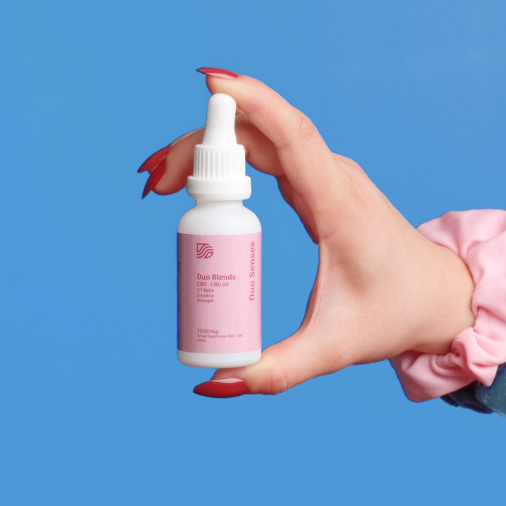 Hand holding Duo Senses CBD CBG Duo Blends oil bottle