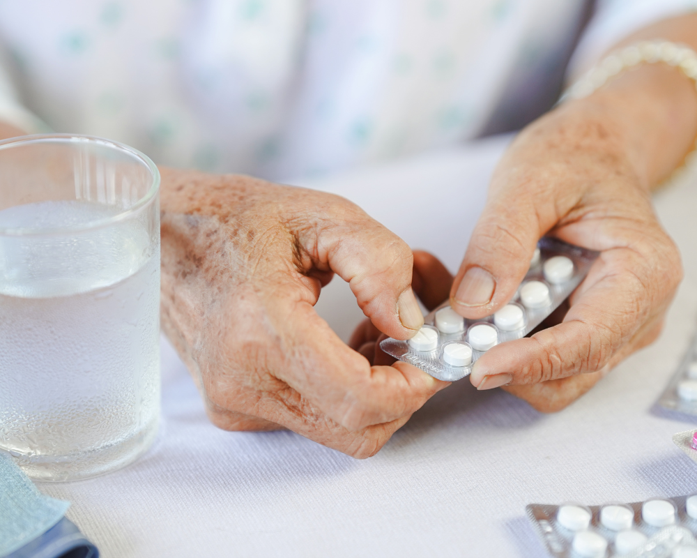 Senior taking prescription medication with a glass of water