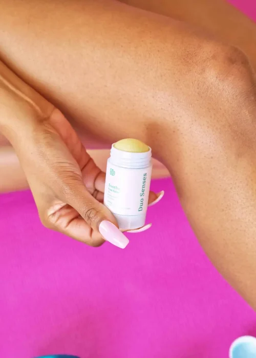 Duo Senses Soothe CBD pain balm being rolled onto knee for targeted pain relief