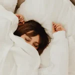 Woman waking up in bed refreshed after using Duo Senses CBD sleep support products